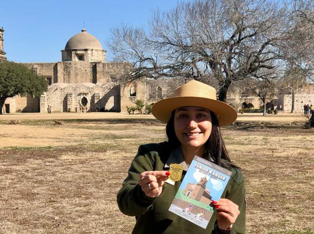 Park Ranger holding Junior Ranger booklet and medal