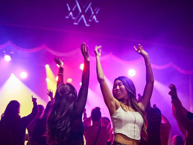 Two girls dancing with their arms up
