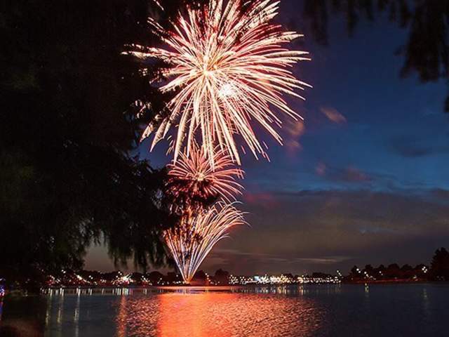 Fireworks going off over lake