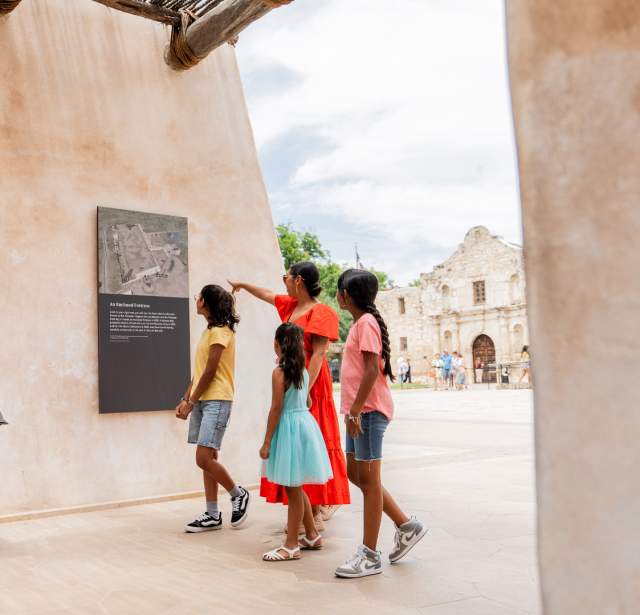 Family walking through exhibit outside of the Alamo in San Antonio, Texas.