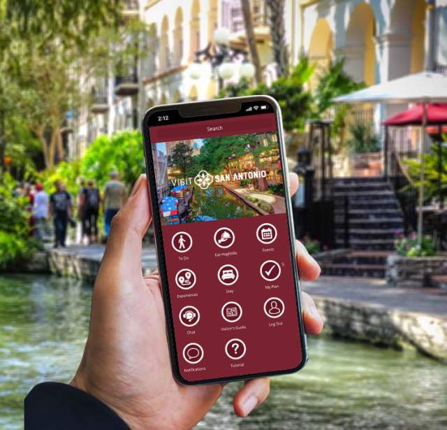 Hand holding a phone with the Visit San Antonio App
