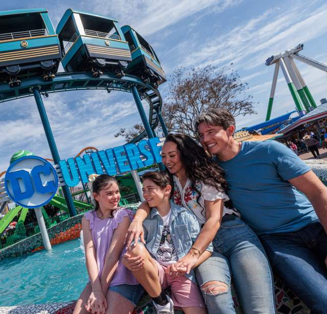Family hugging in front of ride.