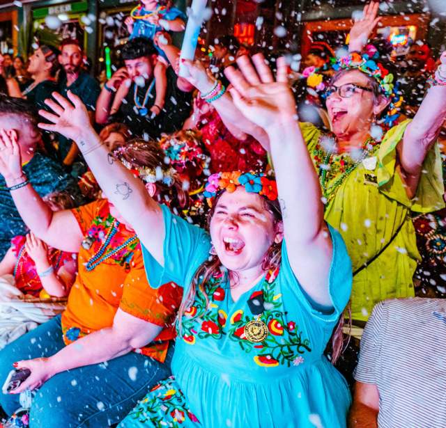 Group of people cheering with confetti at Fiesta San Antonio.