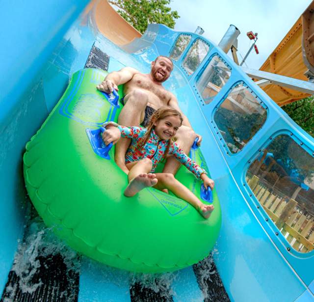 Father and daughter on waterslide together.