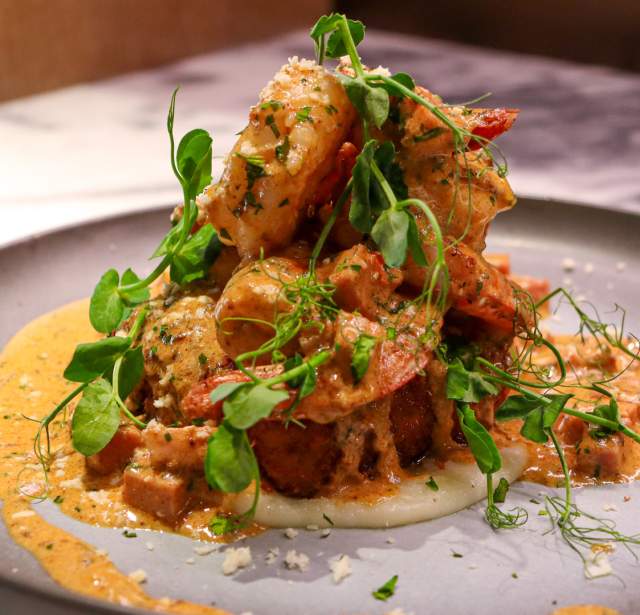 Plated dish with creamy toppings on top of it.