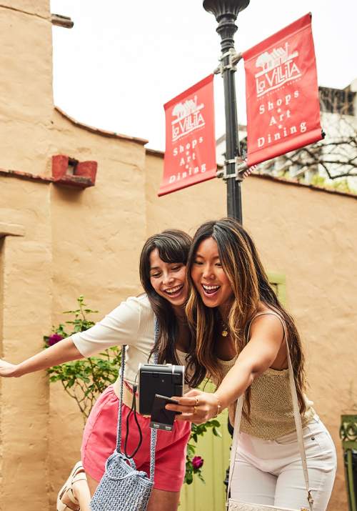 Two girls taking a selfie in outdoor shopping area