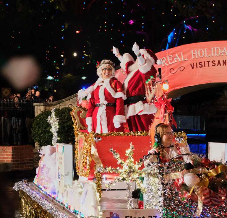 Santa and Mrs. Claus on parade float at Ford Holiday River Parade on the River Walk.