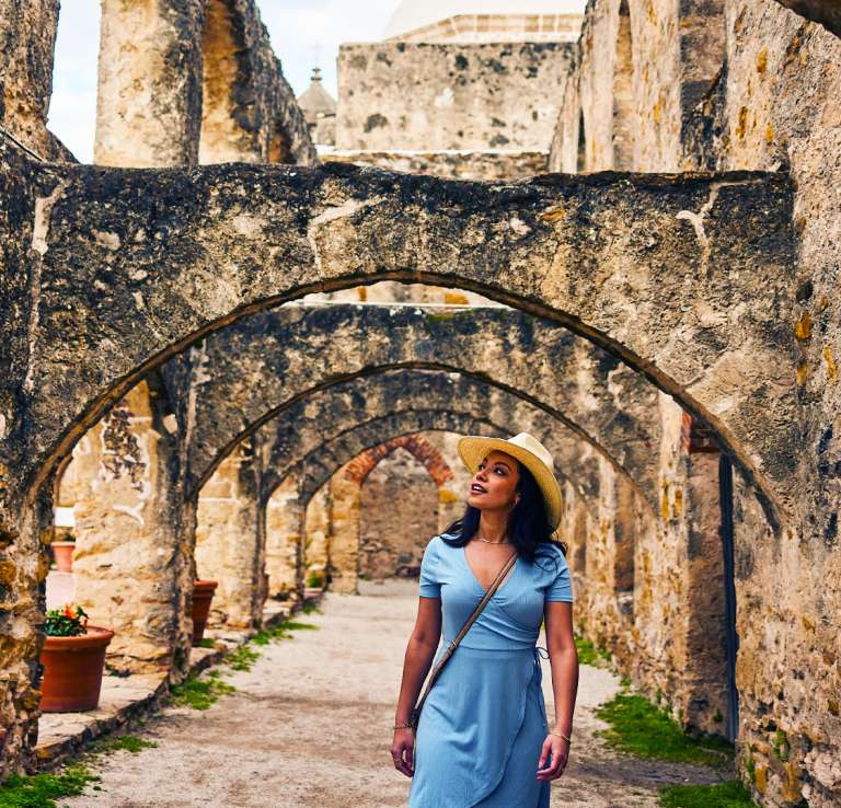 Woman walking under arches at missions