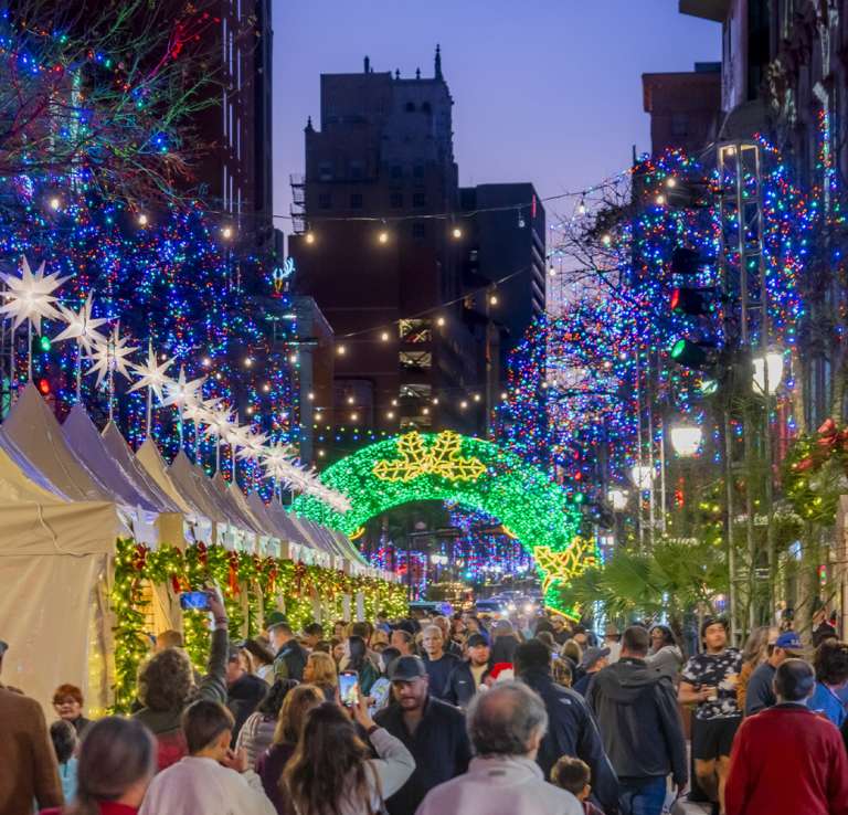 Christmas and lights lit up above outdoor street market on Houston Street in San Antonio.