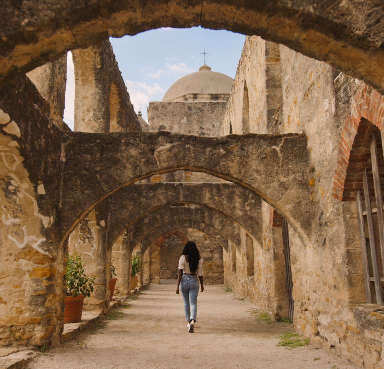 Woman walking through San Antonio Missions National Historial Park pathway