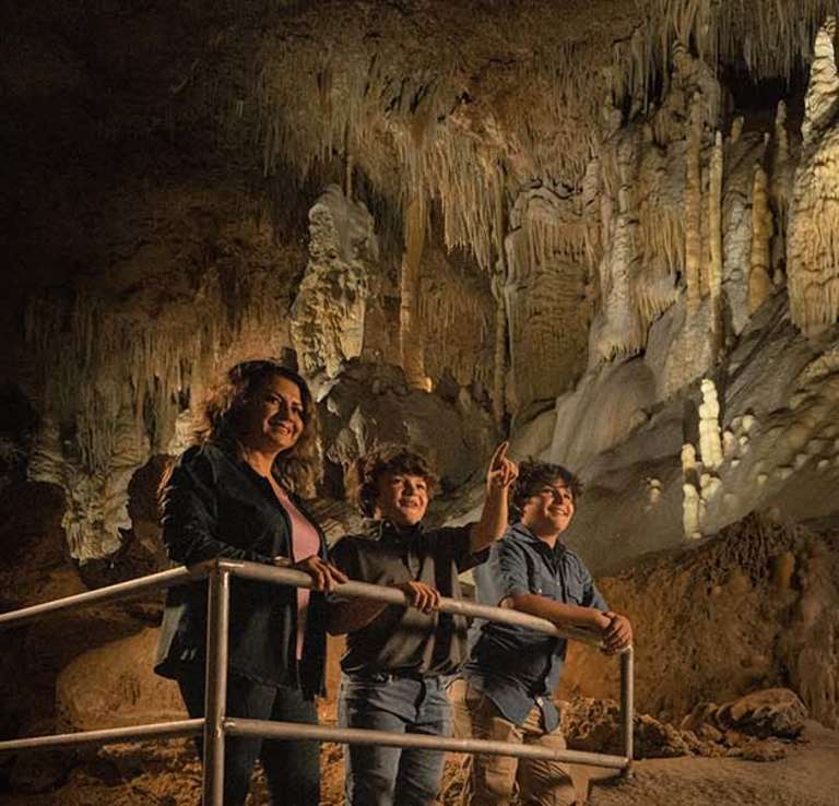 Mother and two sons exploring inside cave at Natural Bridge Caverns in San Antonio.