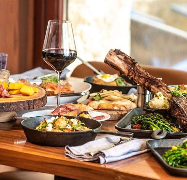 Spread of food with two wine glasses