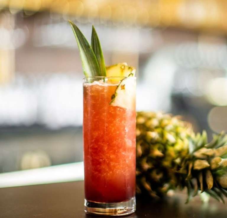 Adult beverage next to a pineapple