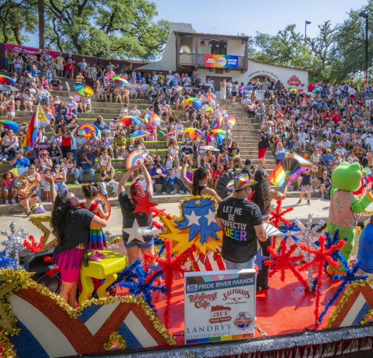 View of river barge floating by large group of people