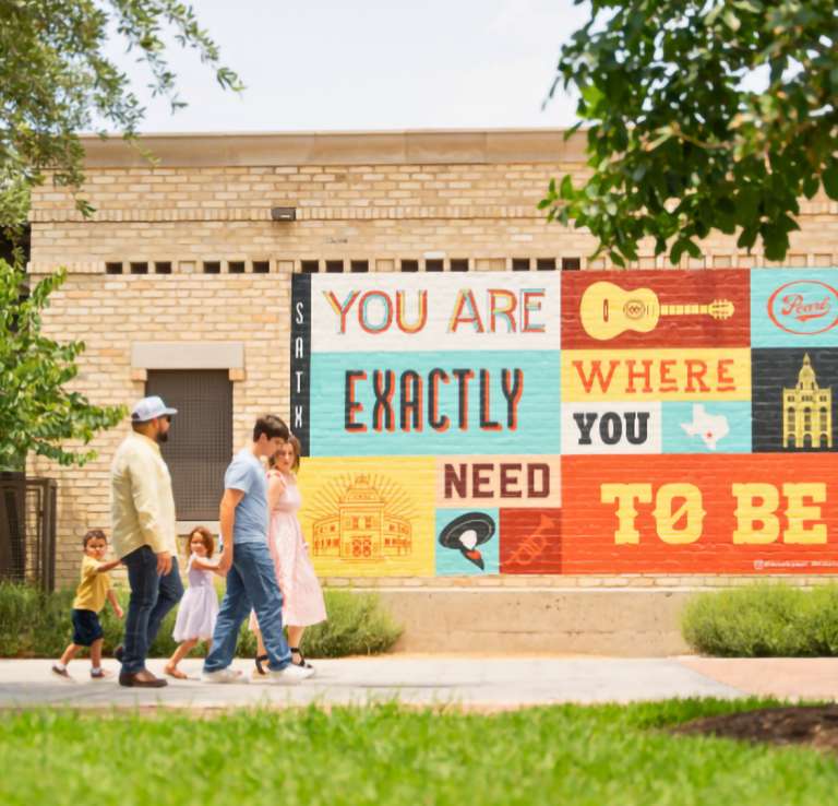 Family walking by the Exactly Where You Need to Be Mural at the Pearl