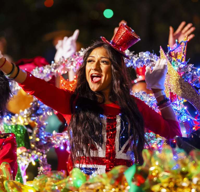 Participants waving from river barge with holiday decorations