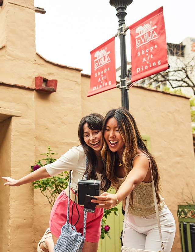 Two girls taking a selfie in outdoor shopping area