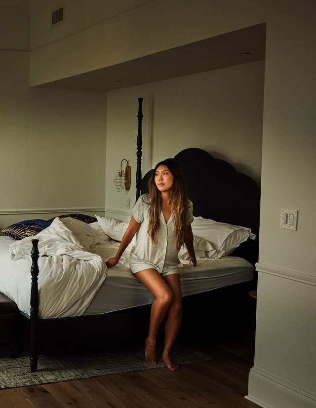 Woman getting out of bed in hotel room