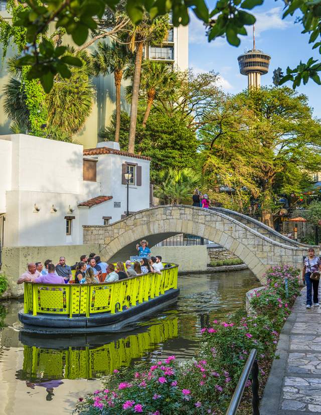 San Antonio River Walk with a barge and Tower of America