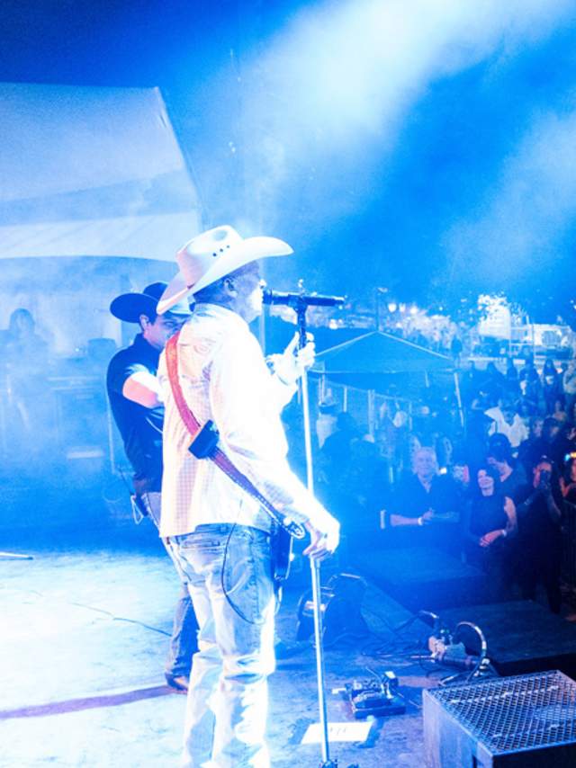 Man playing guitar and singing to crowd at Fiesta San Antonio.