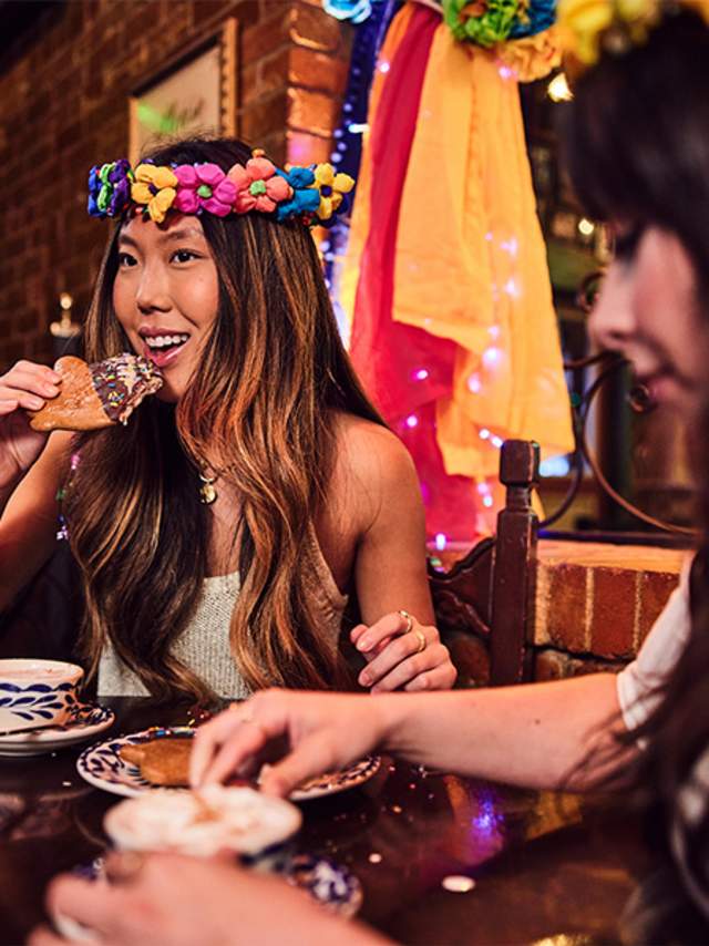 Girl eating pastry dunked in hot chocolate