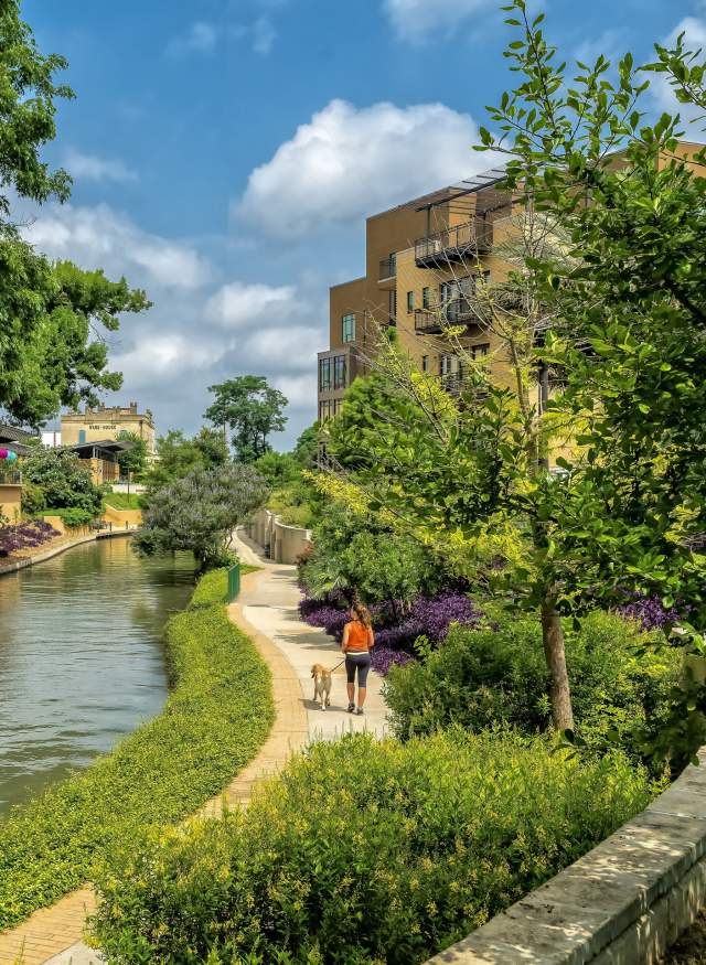 Woman walking dog along Museum Reach of River Walk