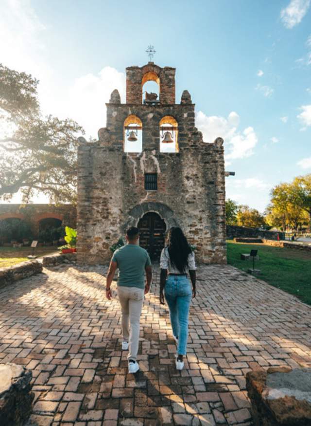 Two people walking toward mission