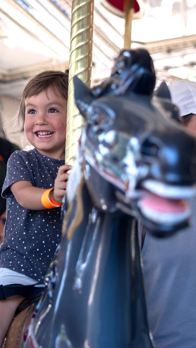 child and family on carousel ride