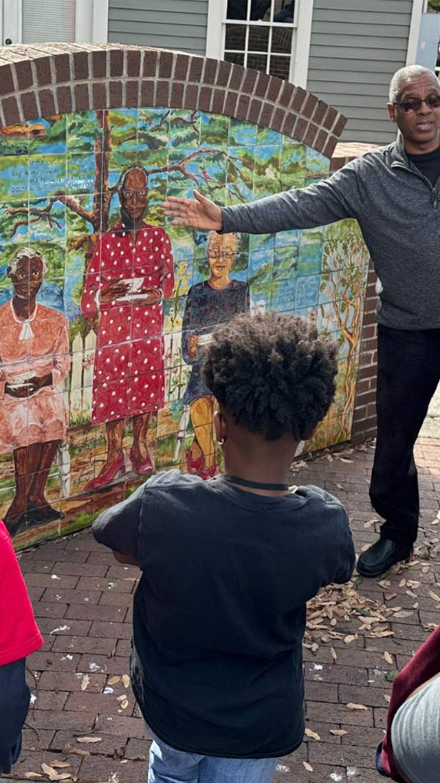 Man explaining piece of artwork to group