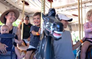 child and family on carousel ride