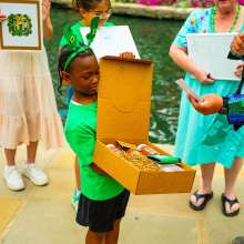 child holding prize box at river walk