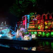 Night parade with river barge decorated with Dia de los Muertos decor