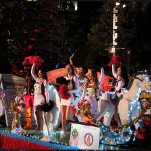 Group of people waving on holiday themed float
