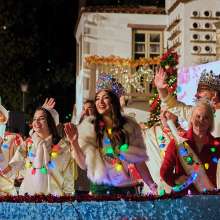 People dressed as fake royalty with holiday light necklaces