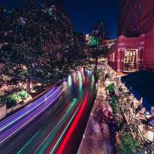 River Walk with holiday lights and glow from river barge