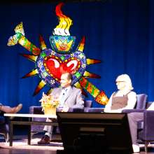 staff discussing on a panel on a stage