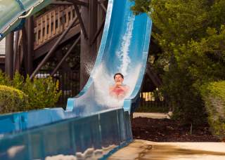 Man splashing down water slide at JW Marriott San Antonio Resort.