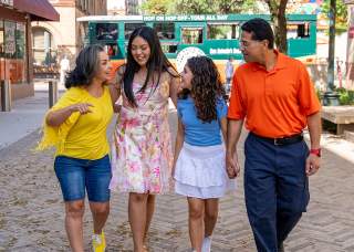 Family laughing in front of Old Town Trolley Tours bus.