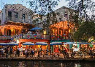 People dining along the San Antonio River Walk.