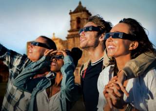 Group of people with protective sunglasses on in front of San Antonio Missions National Historical Park