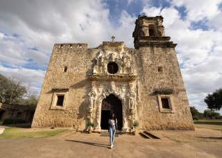 Woman standing in front of San Antonio Mission
