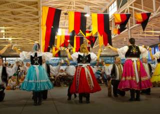 Group of people in German attire dancing.