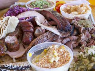 Plated barbecue dish with meats and sides at 2M Smokehouse in San Antonio.