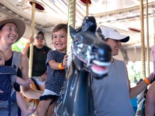 child and family on carousel ride