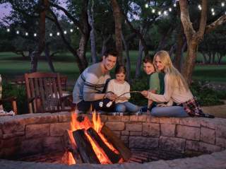 Family sitting be campfire outside