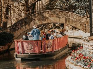Barge carrying people floating down River Walk