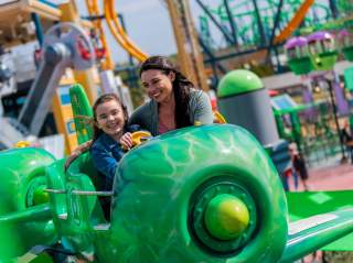 Mother and daughter smiling on Green Lantern ride at Six Flags Fiesta Texas.