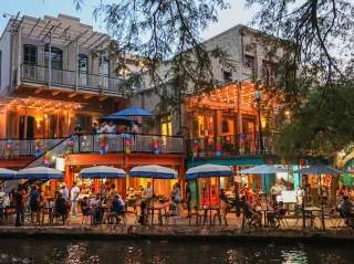 People dining along the San Antonio River Walk.