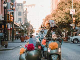 Woman driving vespa with passenger in side car in San Antonio, Texas.