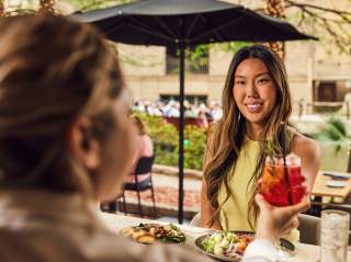 Woman accepting drink from waitress and smiling